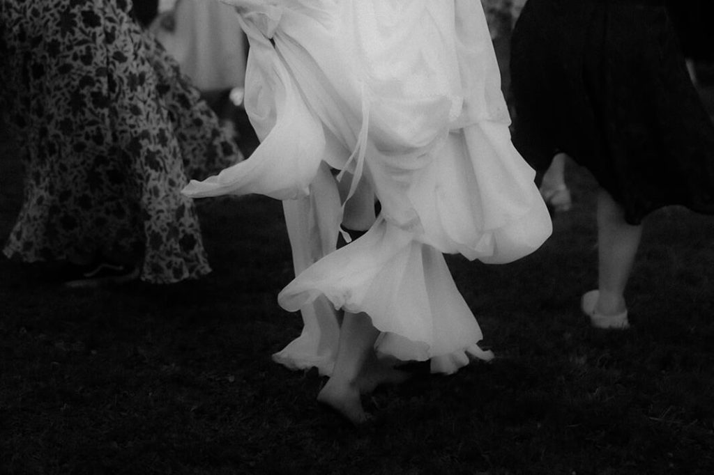 Une mariée danse pieds nus pendant le cocktail de son mariage intimiste à la maison dans les Landes.
