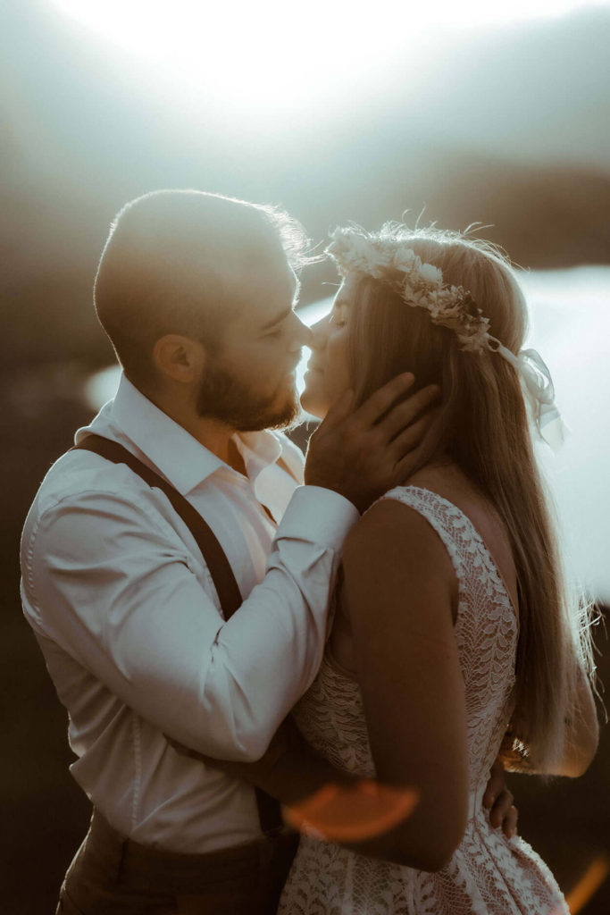 Le couple s'apprête à s'embrasser avec la belle lumière dorée du coucher de soleil. Une photo capturé par la photographe de couple Gaétane Glize dans les Landes.