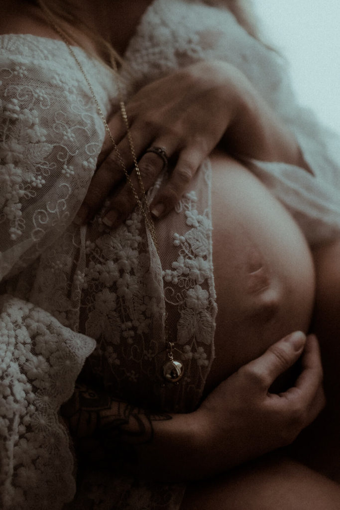 Gros plan du ventre d'une femme enceinte, mis en valeur par la photographe de grossesse et maternité Gaétane Glize pendant une séance photo grossesse dans les landes.