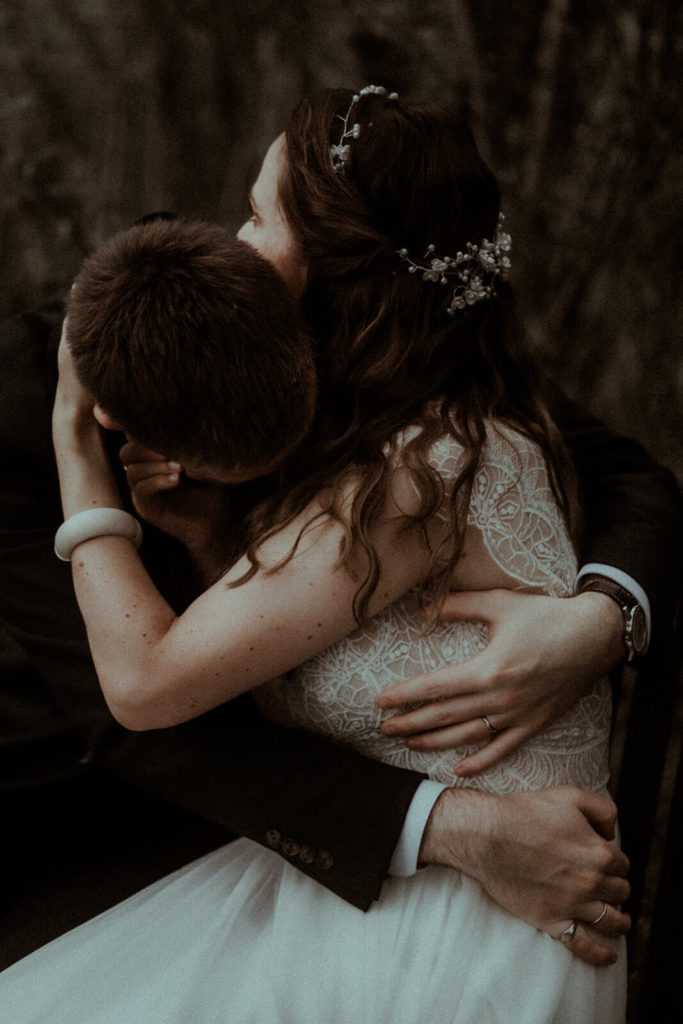 Un couple de mariés se serre très fort dans les bras. Un moment de tendresse capturé pendant leur mariage dans un château dans les Landes par la photographe de mariage Gaétane Glize.
